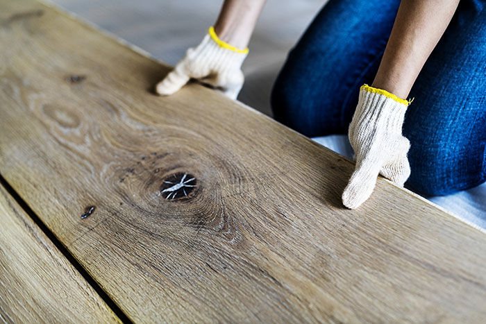 Hardwood flooring is being installed in a residential living room.