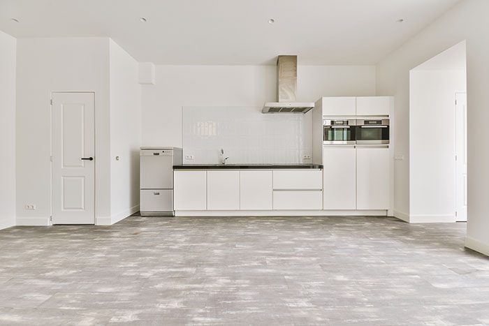 Modern kitchen with light-colored tile flooring and stainless steel appliances.